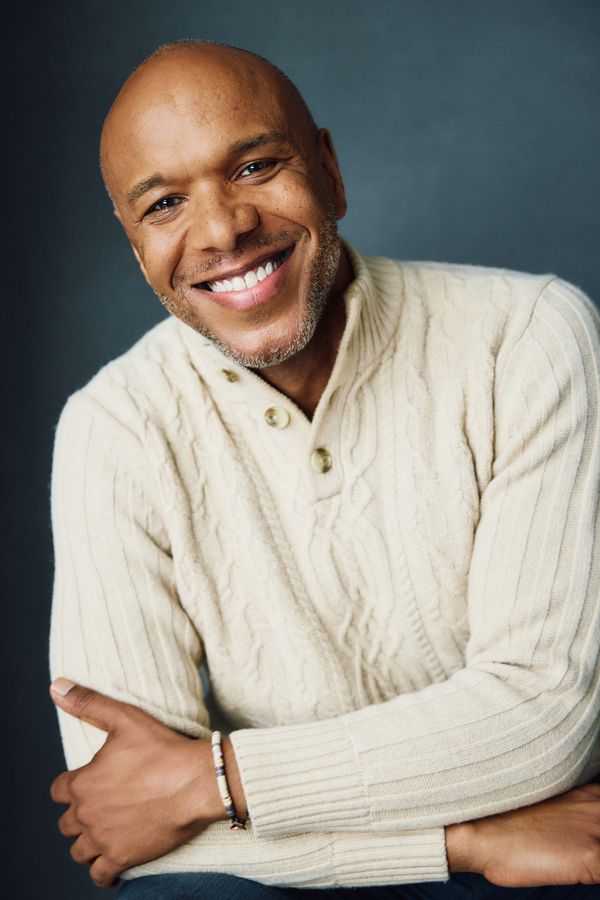 Alfred C. Kemp headshot, cream cable-knit sweater on dark backdrop, smiling